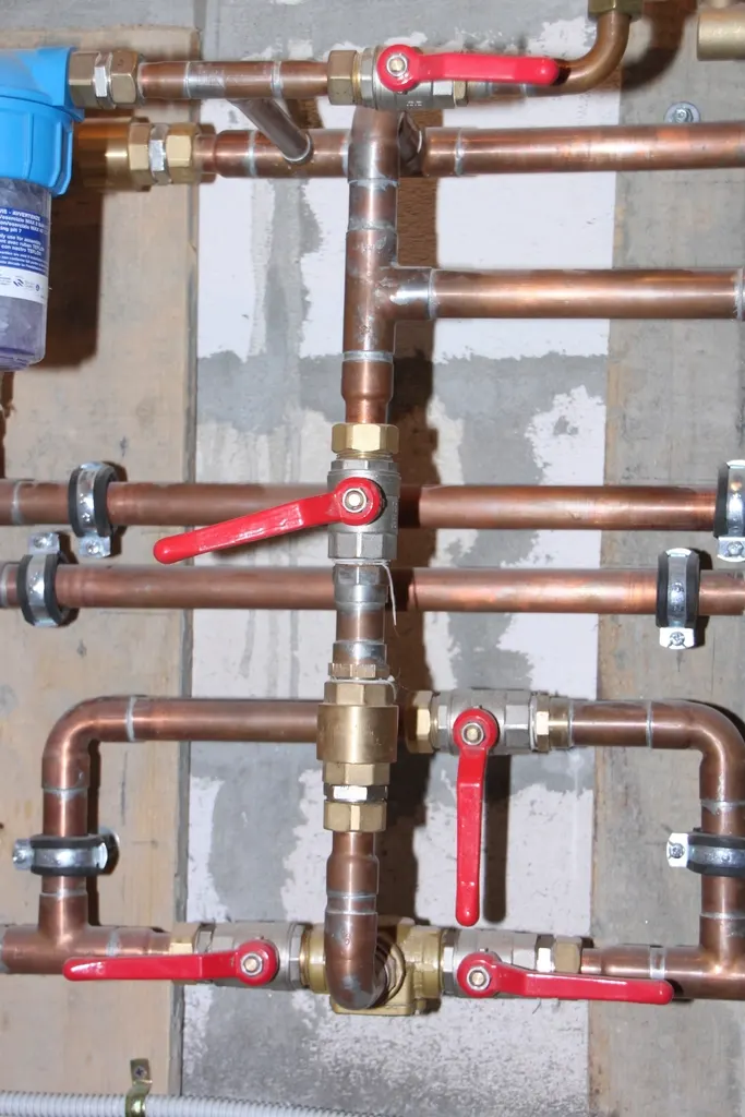 Copper water supply pipes and shutoff valves like those that run under a slab foundation